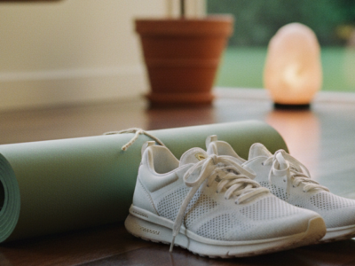 A yoga mat and sneakers in a bright room, showing a mindful way to build strength with a home workout routine.