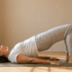Woman in her late 40s doing a gentle bridge exercise on a yoga mat representing pelvic floor exercises for women over 40