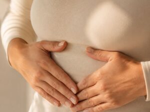 Breathing and pelvic floor after 40 — hands resting on lower ribcage — how diaphragmatic breathing affects pelvic floor coordination in midlife women