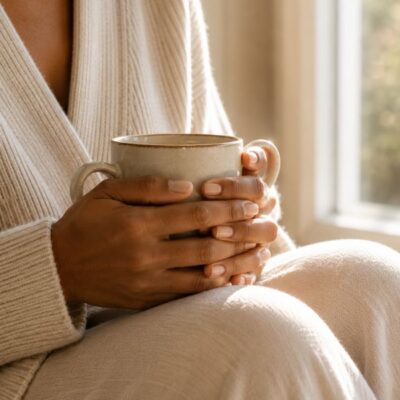 Pelvic floor daily life after 40 — woman's hands holding ceramic mug by bright window — how pelvic floor dysfunction affects confidence activity and daily life in midlife