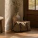 Pelvic floor and travel after 40 — small travel bag by front door in morning light — how pelvic floor symptoms affect travel and what helps in midlife women