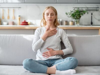 Leaking when you lift something heavy — woman practicing calm breathing with hands on chest and belly — connecting breath and core coordination to pelvic floor support