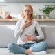 Leaking when you lift something heavy — woman practicing calm breathing with hands on chest and belly — connecting breath and core coordination to pelvic floor support